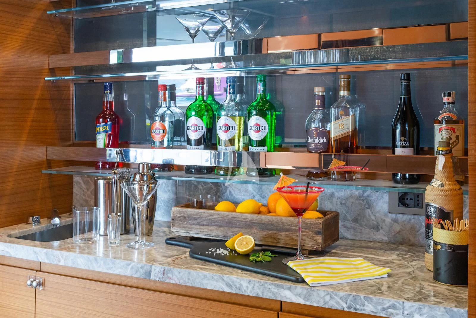 a kitchen counter with bottles and glasses aboard TAKARA ONE Yacht for Charter