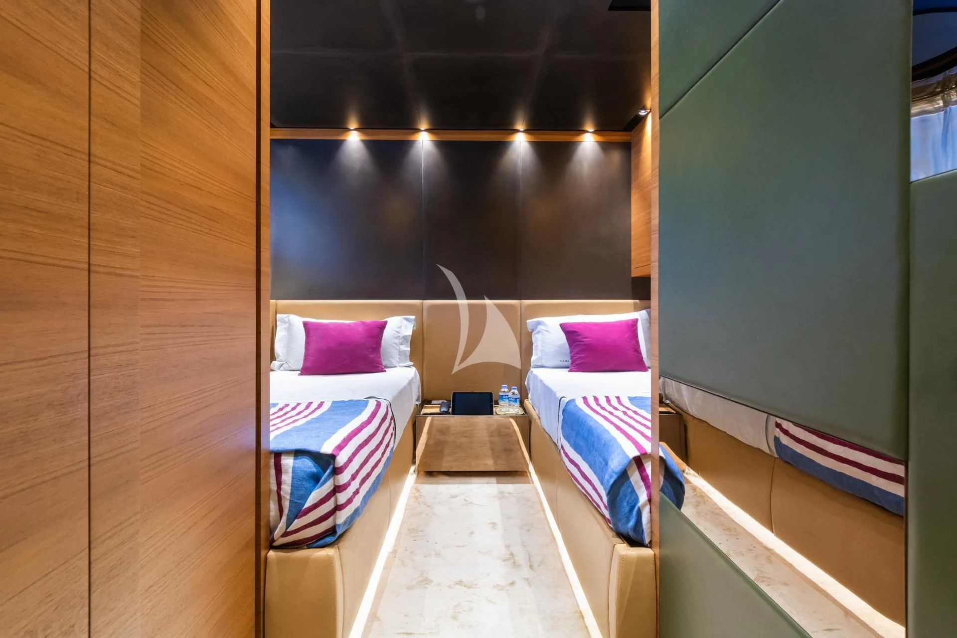 a room with beds and a bed aboard TAKARA ONE Yacht for Charter