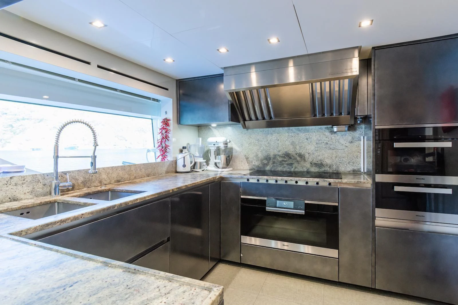 a kitchen with black appliances aboard TAKARA ONE Yacht for Charter
