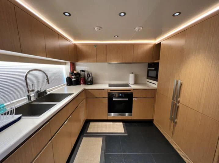 a kitchen with wooden cabinets aboard CAROBELLE Yacht for Sale