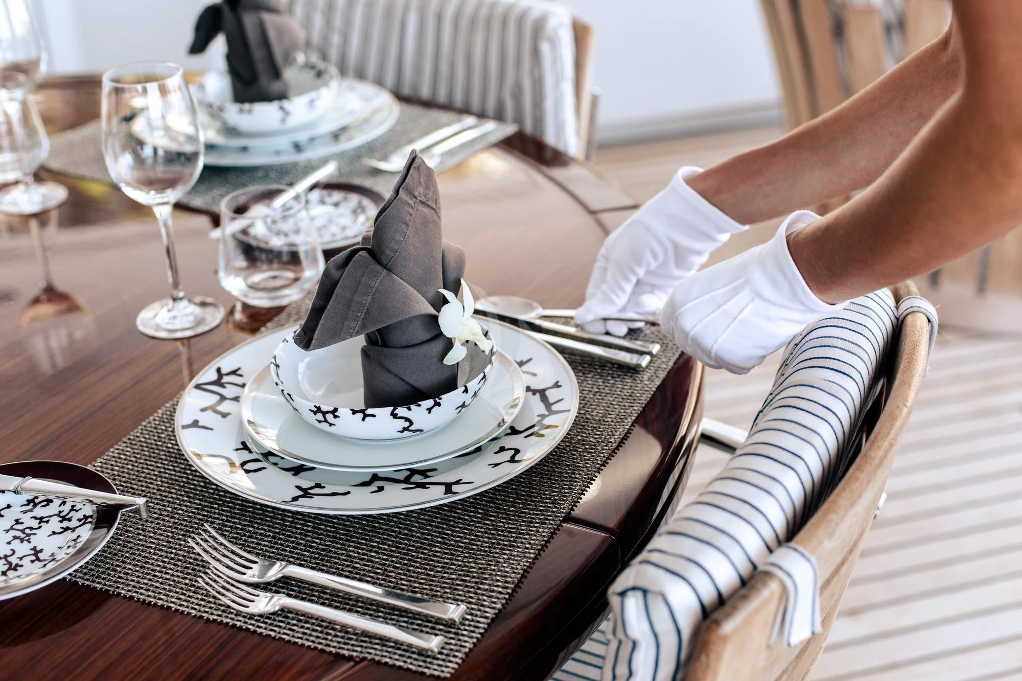a person sitting at a table with a cake and glasses aboard SARON Yacht for Sale