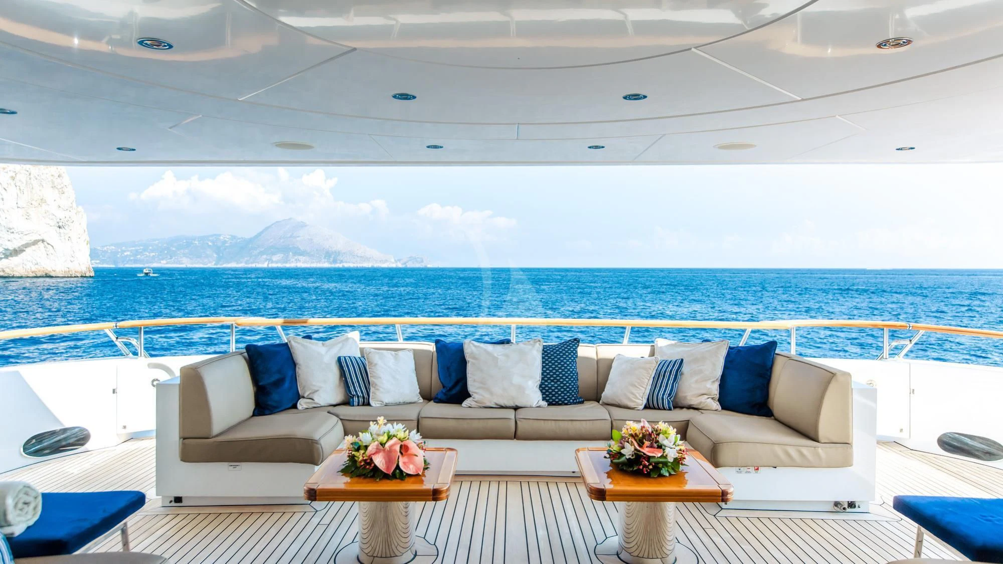 a living room with a large blue ocean and mountains in the background aboard SARON Yacht for Sale