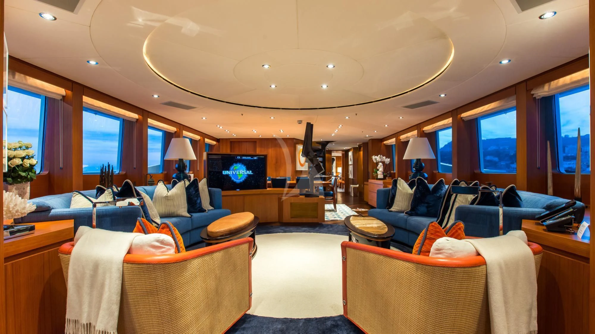 a living room with a large blue couch and a large window aboard SARON Yacht for Sale