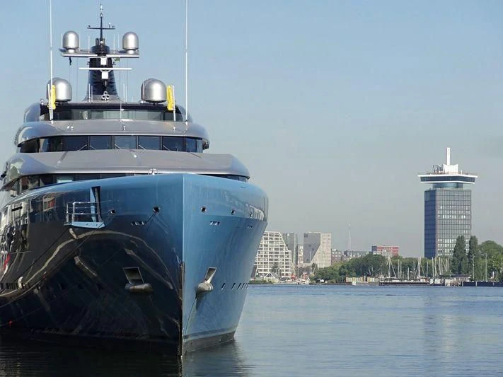 a large boat next to a smaller boat on the water aboard AVIVA Yacht for Sale