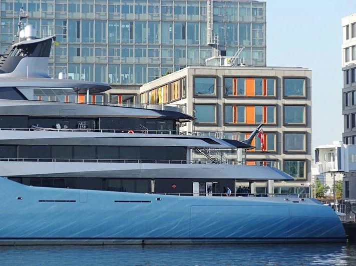 a large cruise ship in front of a tall building aboard AVIVA Yacht for Sale