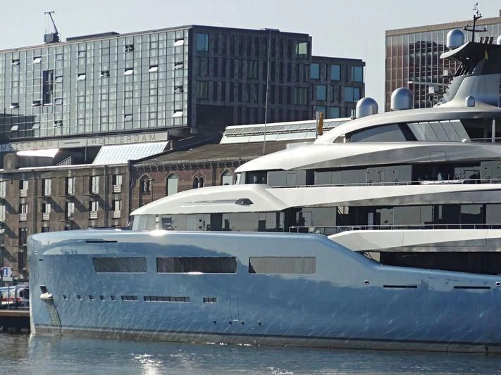 a large white boat sits in front of a building aboard AVIVA Yacht for Sale