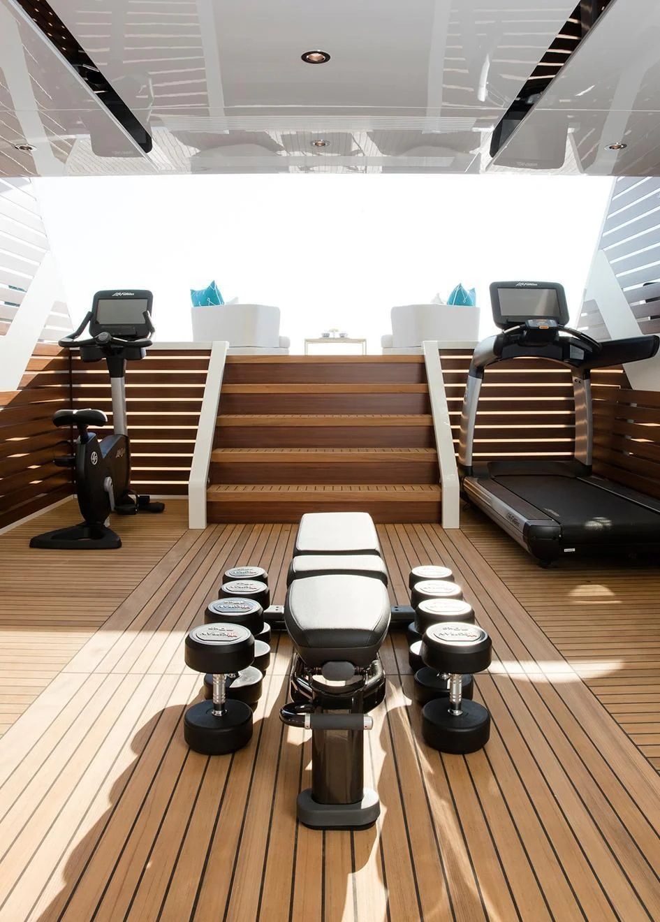 a room with a wood floor and a wood bench and a large window aboard RASHA Yacht for Sale
