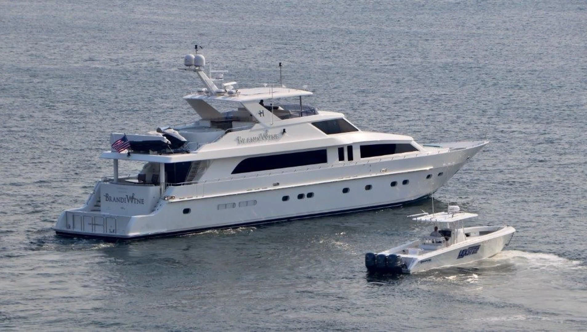 a white yacht with a smaller boat on the water aboard BRANDI WINE Yacht for Charter