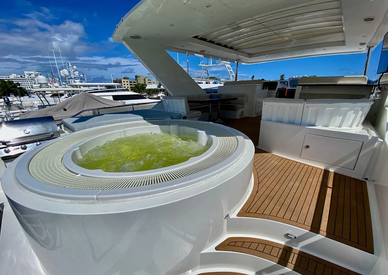 a large white bowl with green liquid in it on a deck with a pool of water and a aboard BRANDI WINE Yacht for Charter