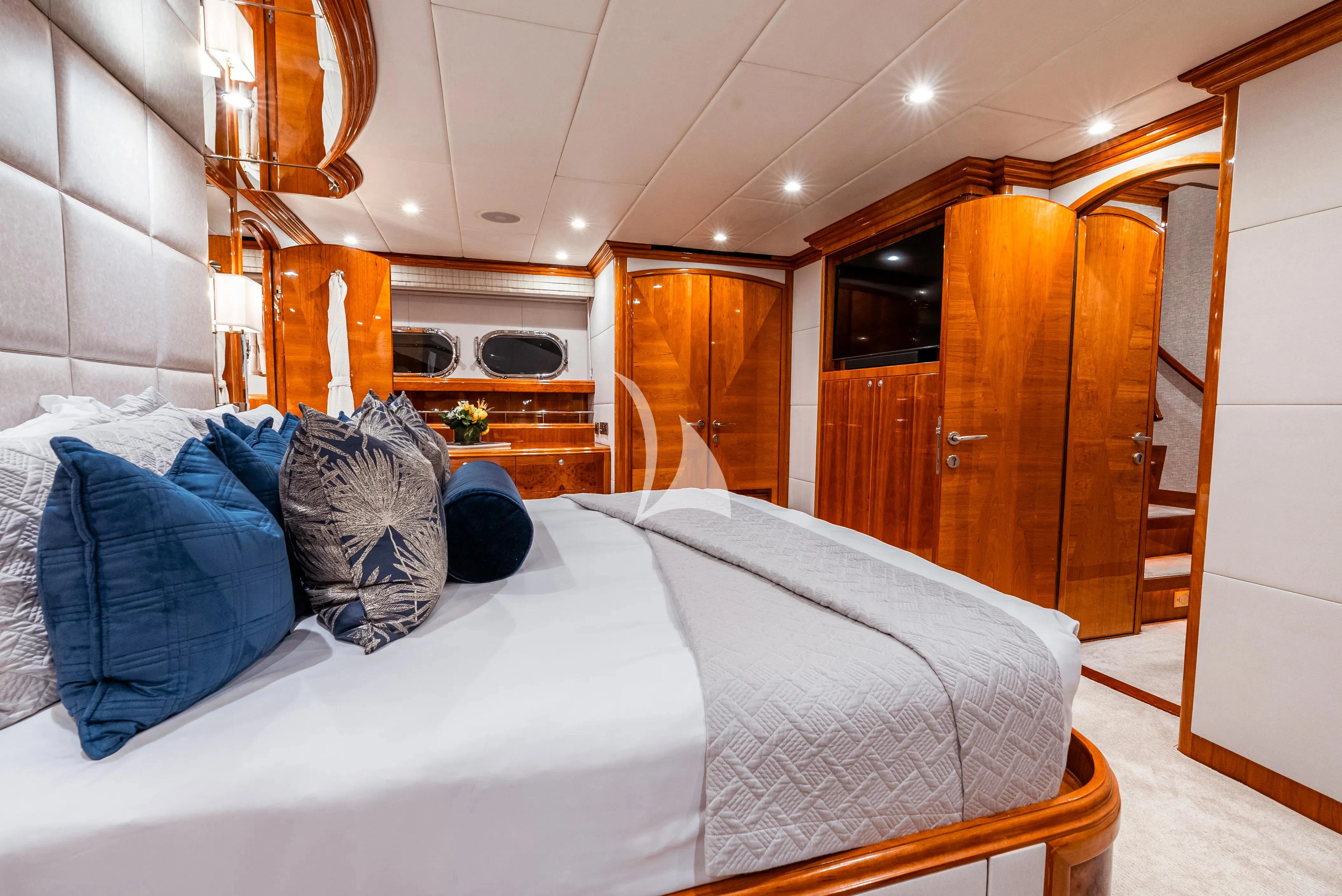 a bedroom with a bed and a wood cabinet aboard BRANDI WINE Yacht for Charter