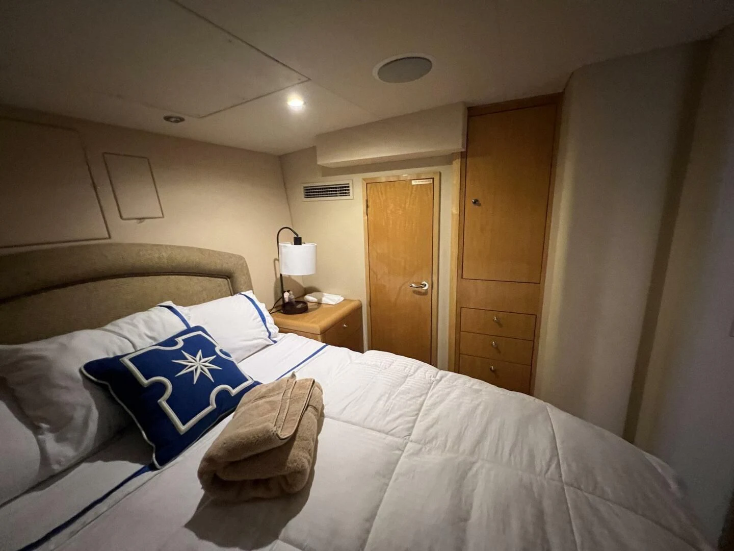 a bed with a white comforter and a blue and white pillow aboard ARETECTE Yacht for Sale