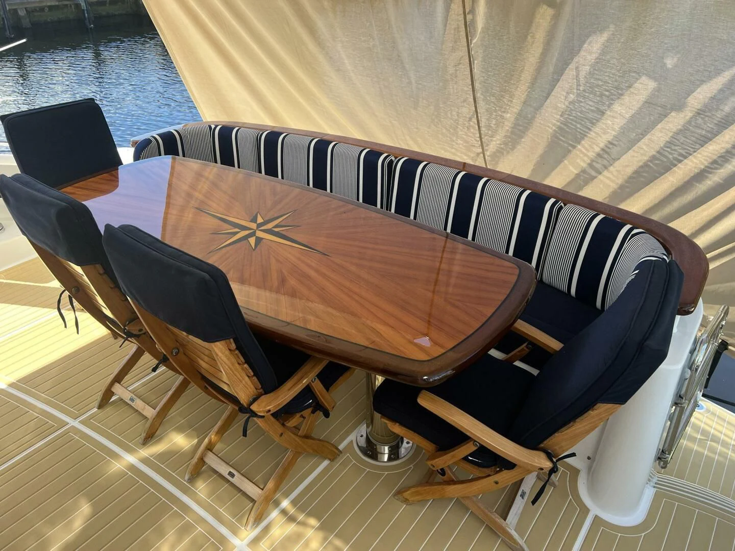 a wooden table with chairs around it aboard ARETECTE Yacht for Sale