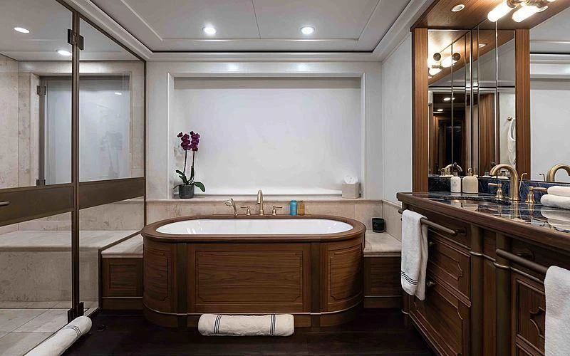 a bathroom with a tub sink and cabinets aboard Q Yacht for Sale
