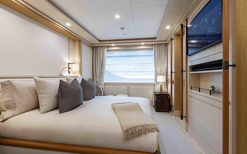 a bed with a white bed spread aboard Q Yacht for Sale