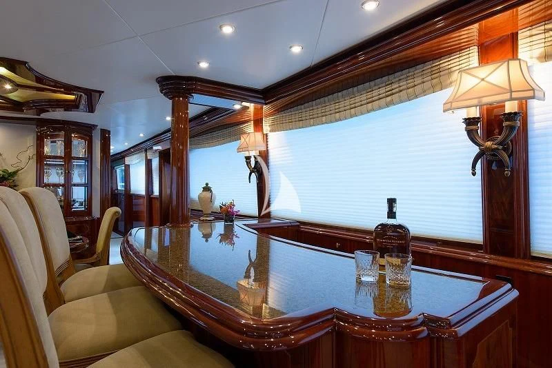 a dining table with a bottle of liquor on it aboard LADY KRISTINA Yacht for Sale