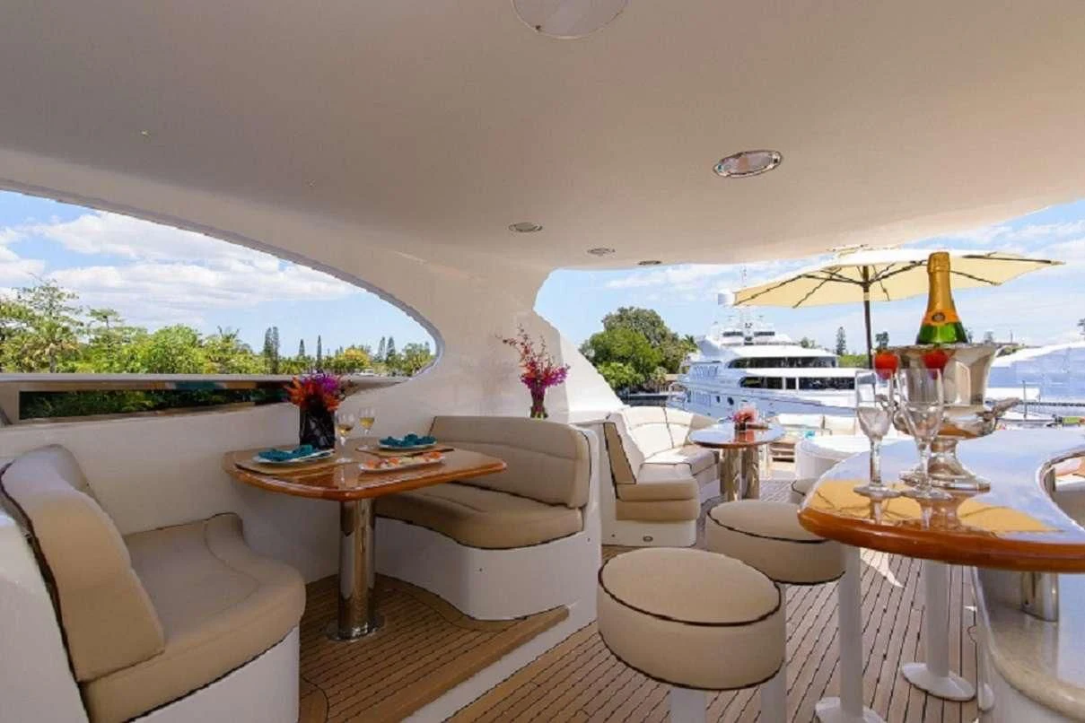 a room with a table chairs and a boat in the water aboard LADY KRISTINA Yacht for Sale