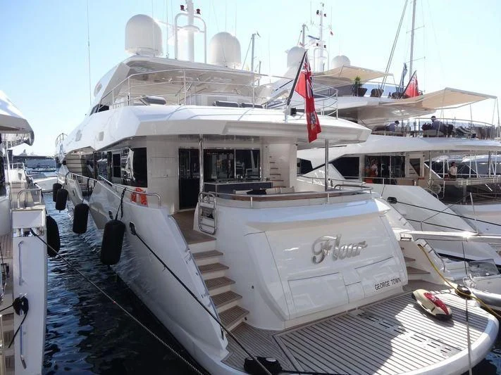 a large white boat with a red and white stripe on the front aboard FLEUR Yacht for Charter