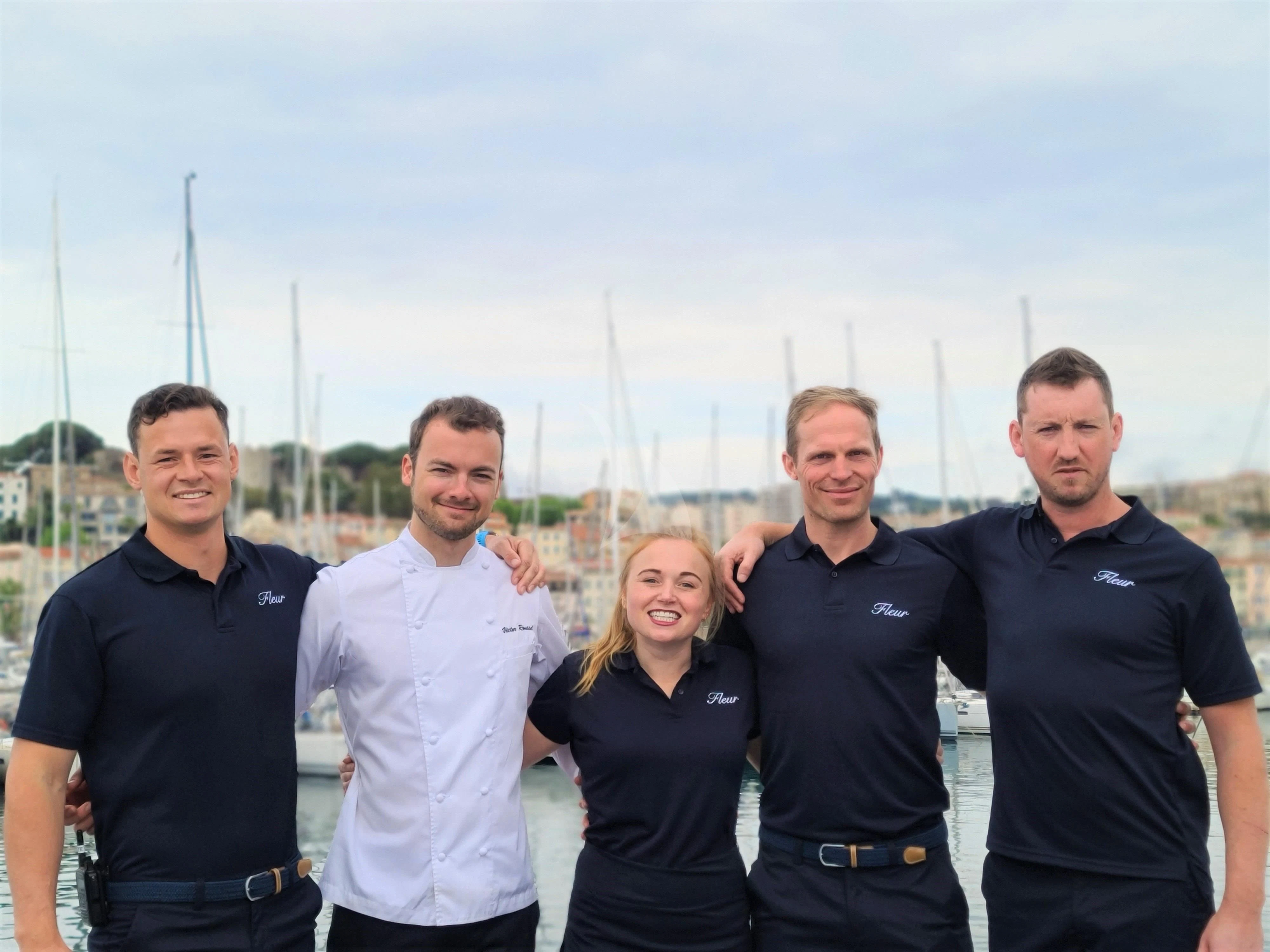 a group of people posing for a photo aboard FLEUR Yacht for Charter