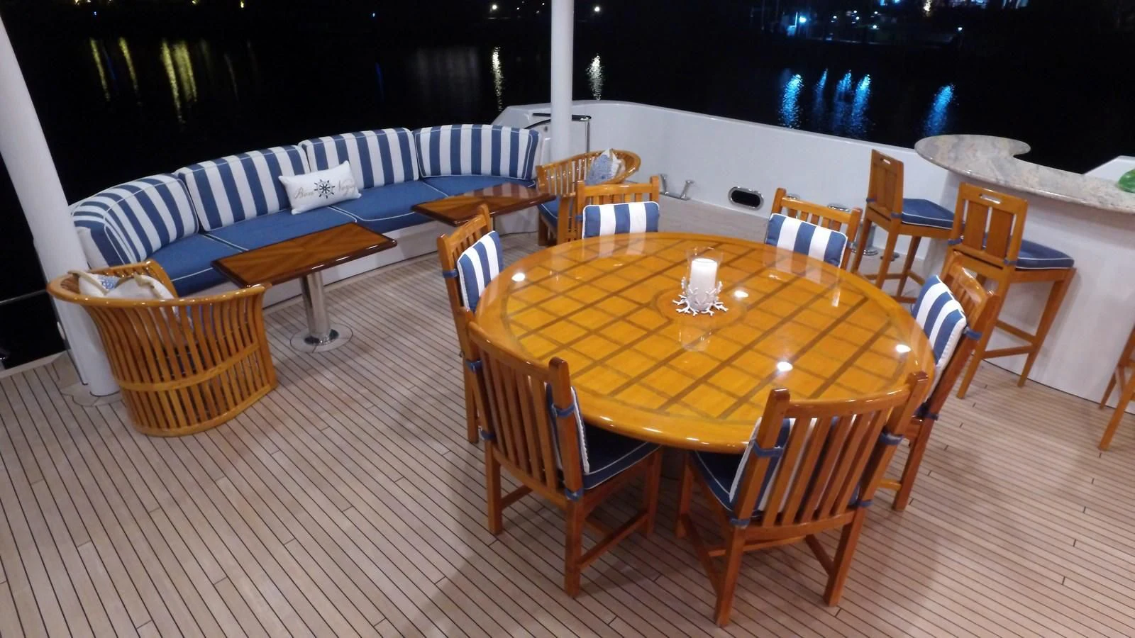 a table set with chairs and a candle on a wooden floor aboard ELYSIAN Yacht for Sale