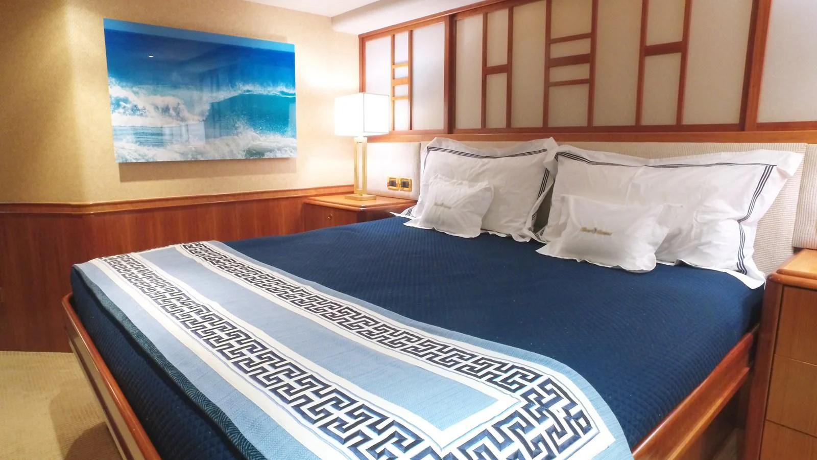 a bed with a blue and white bed spread aboard ELYSIAN Yacht for Sale
