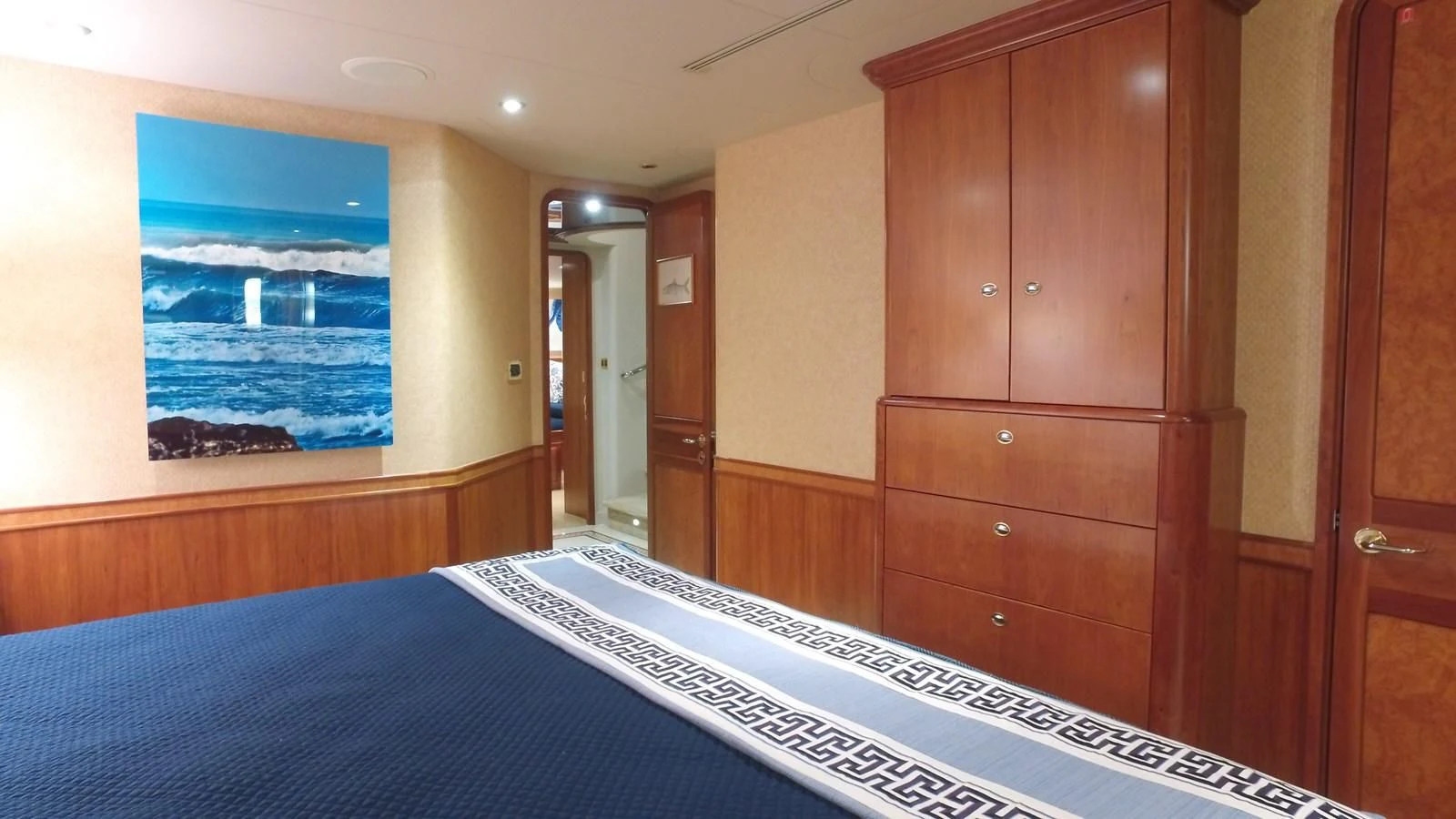a room with a bed and a dresser aboard ELYSIAN Yacht for Sale