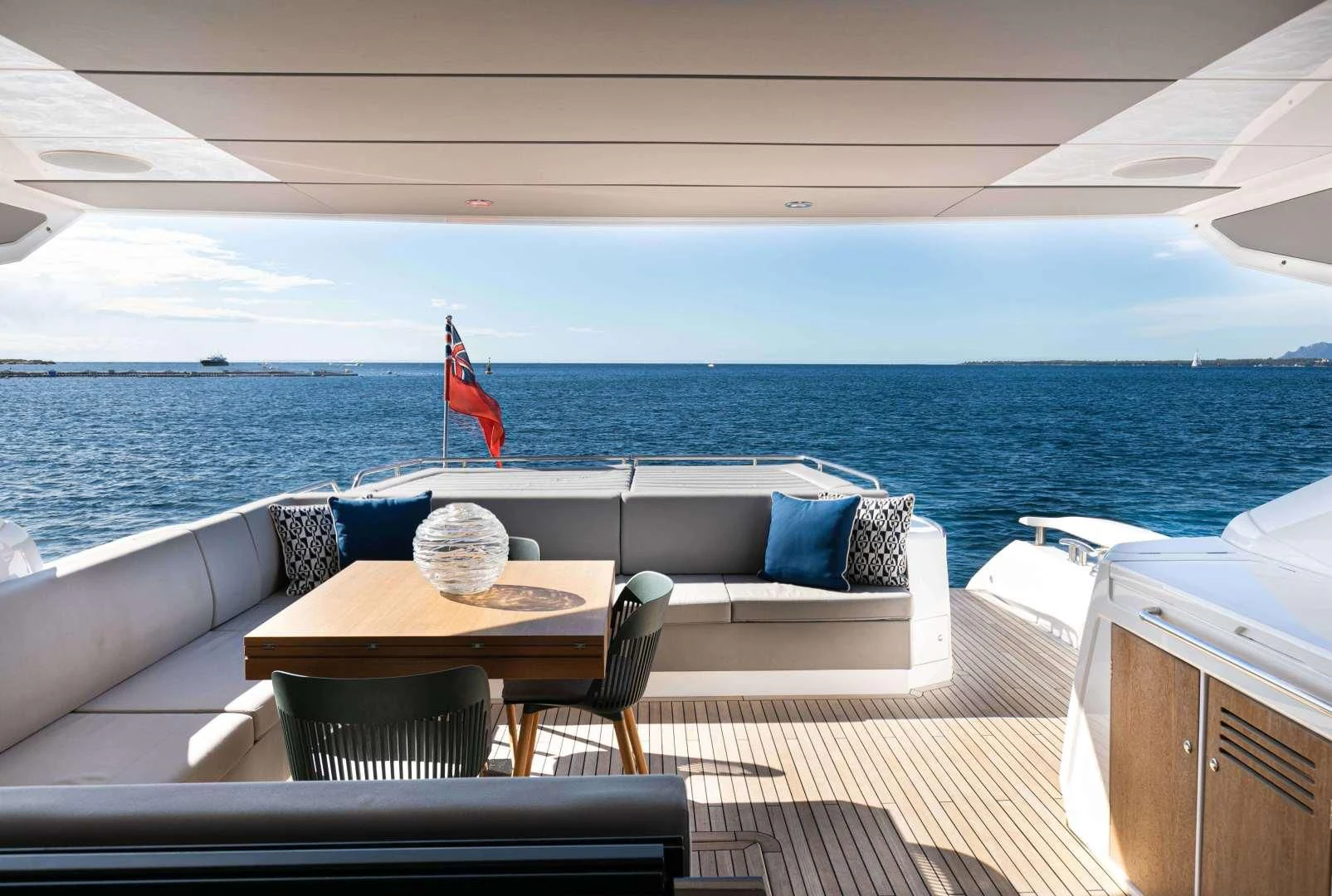 a table and chairs on a deck overlooking the ocean aboard H Yacht for Sale