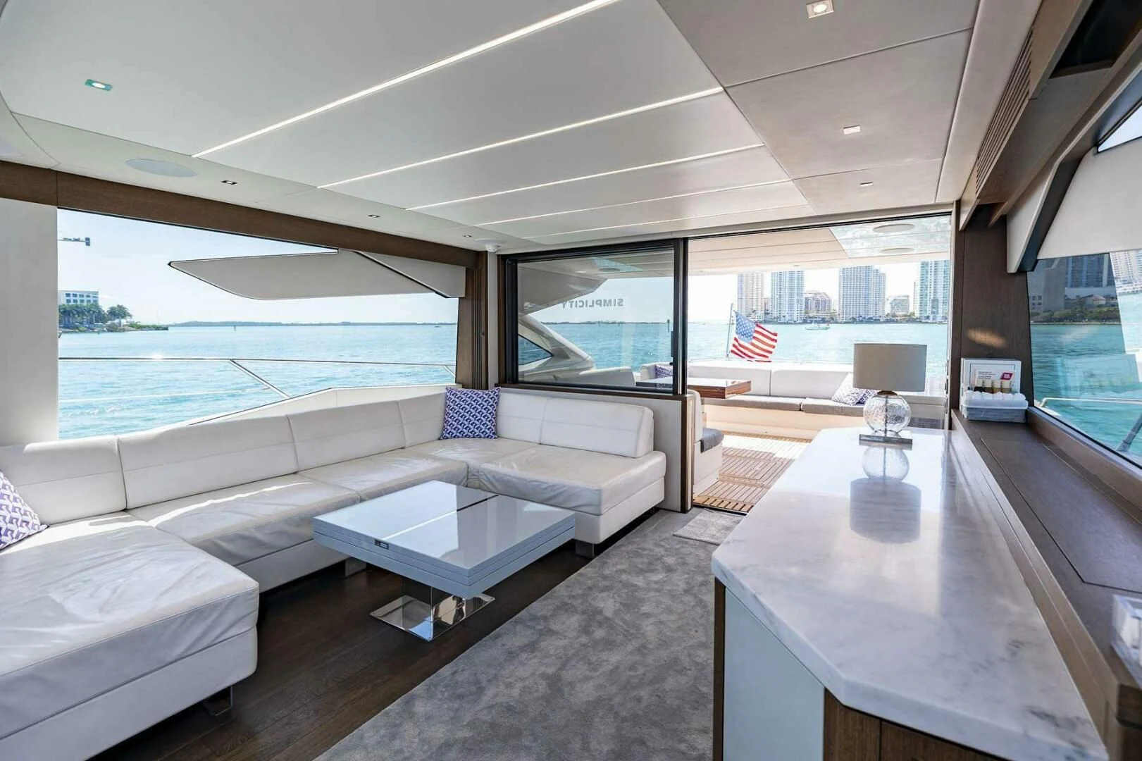 a room with a table and a couch aboard H Yacht for Sale