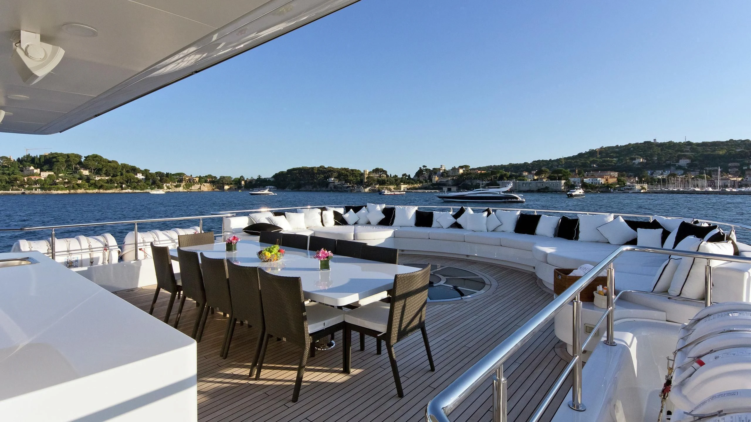 a table and chairs on a deck overlooking a body of water aboard BELLA 2 Yacht for Sale