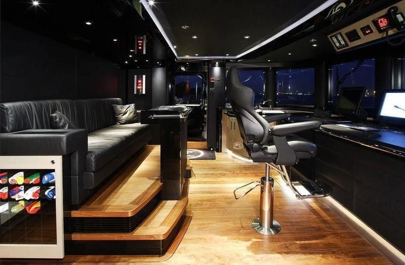 a room with a couch and a table with a chair aboard TALISMAN C Yacht for Charter