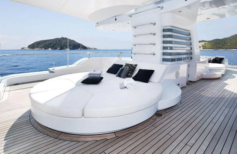 a large white lounge chair on a deck overlooking a large body of water aboard TALISMAN C Yacht for Charter
