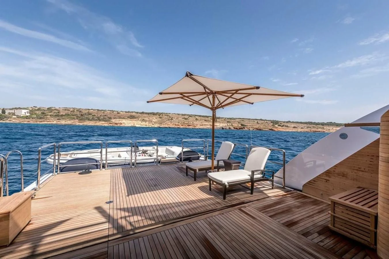 a deck with chairs and umbrellas on it by the water aboard TALISMAN C Yacht for Charter