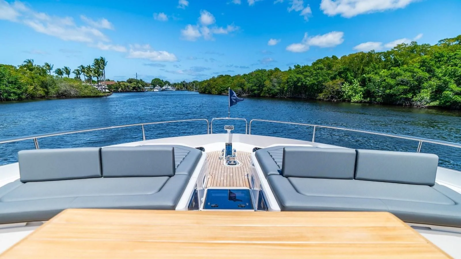 a deck with a view of a lake and trees aboard 76 YACHT Yacht for Sale