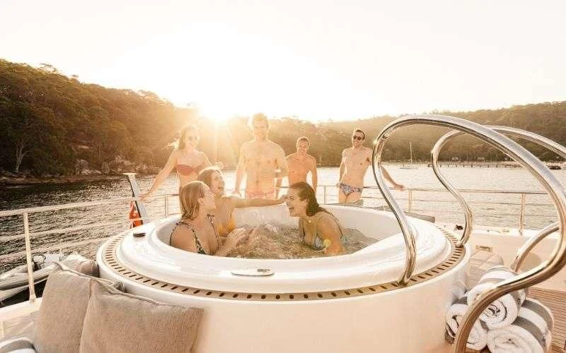a group of people in a bathtub on a beach aboard ONEWORLD Yacht for Sale
