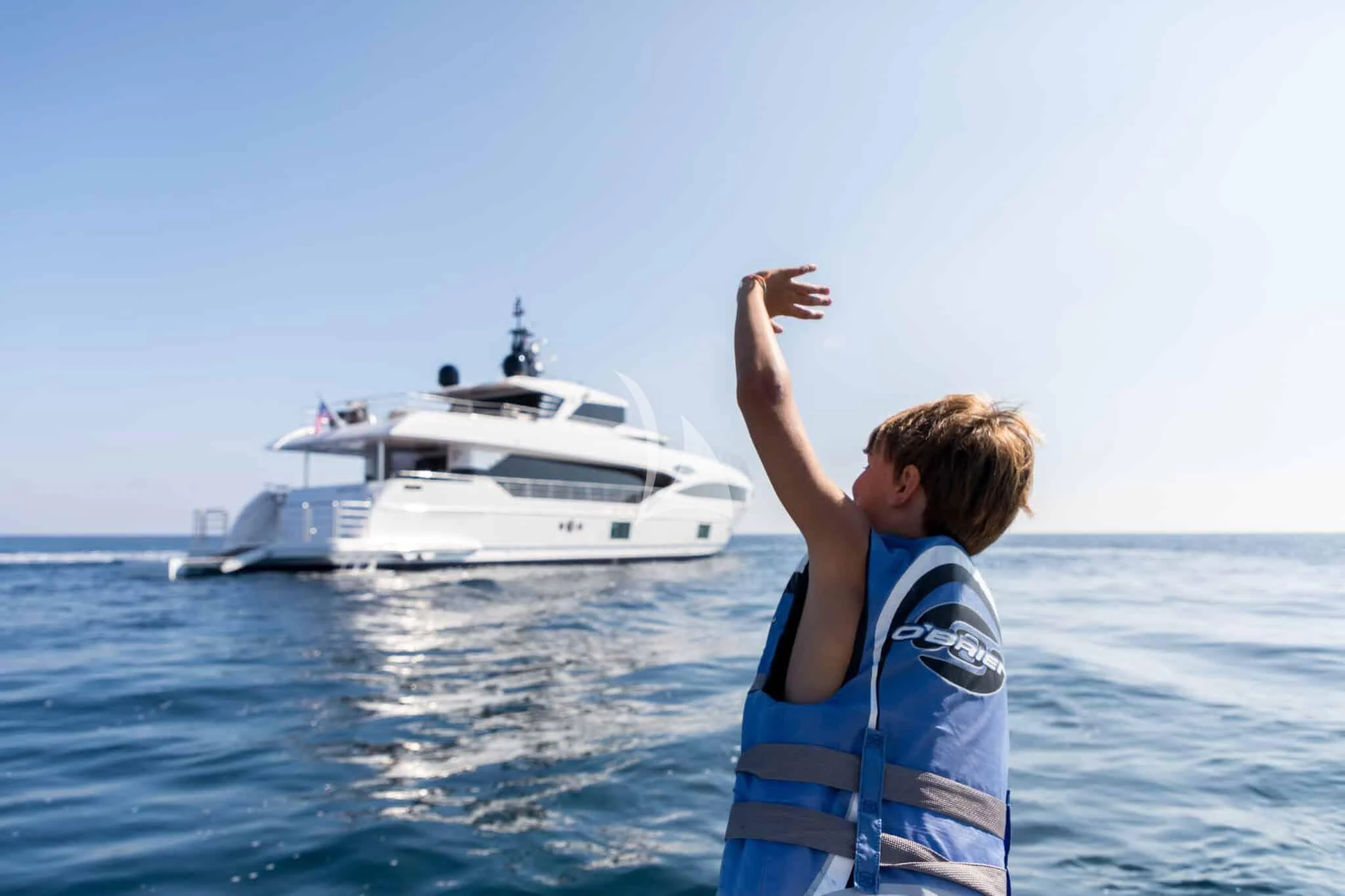 a person standing in the water with the arms up aboard ONEWORLD Yacht for Sale
