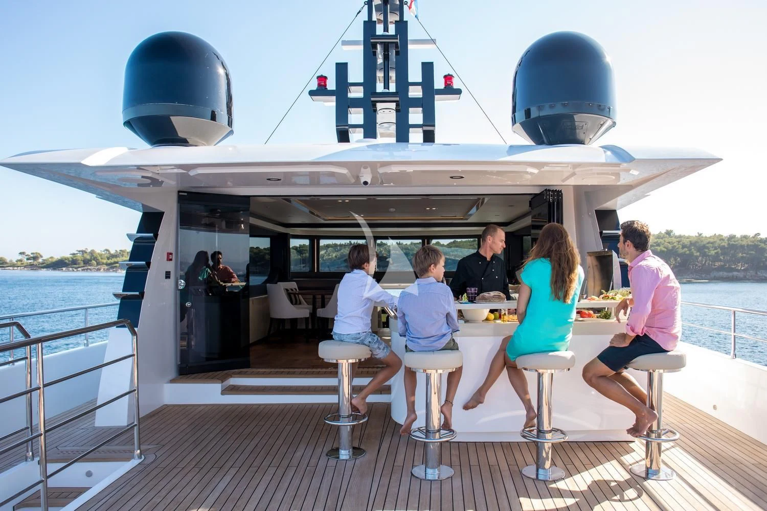 a group of people sitting at a table on a boat aboard ONEWORLD Yacht for Sale