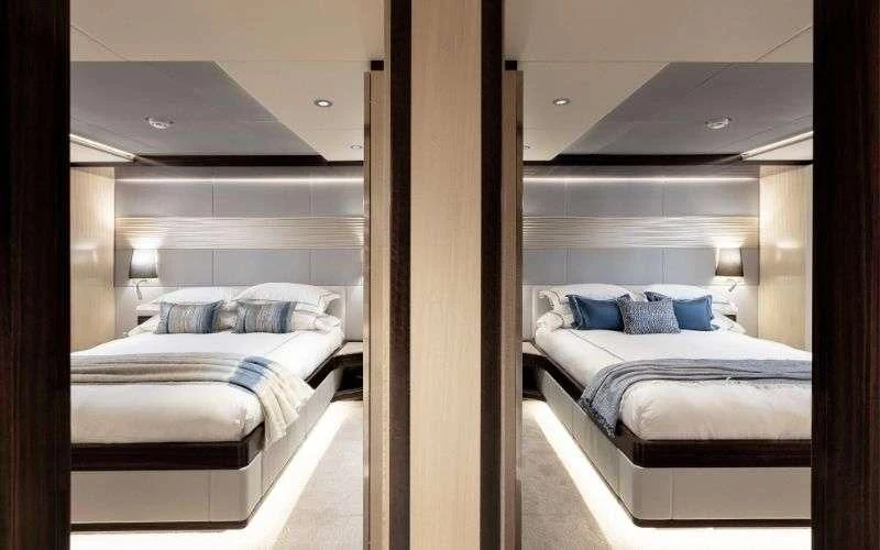 a room with a couple of beds aboard ONEWORLD Yacht for Sale