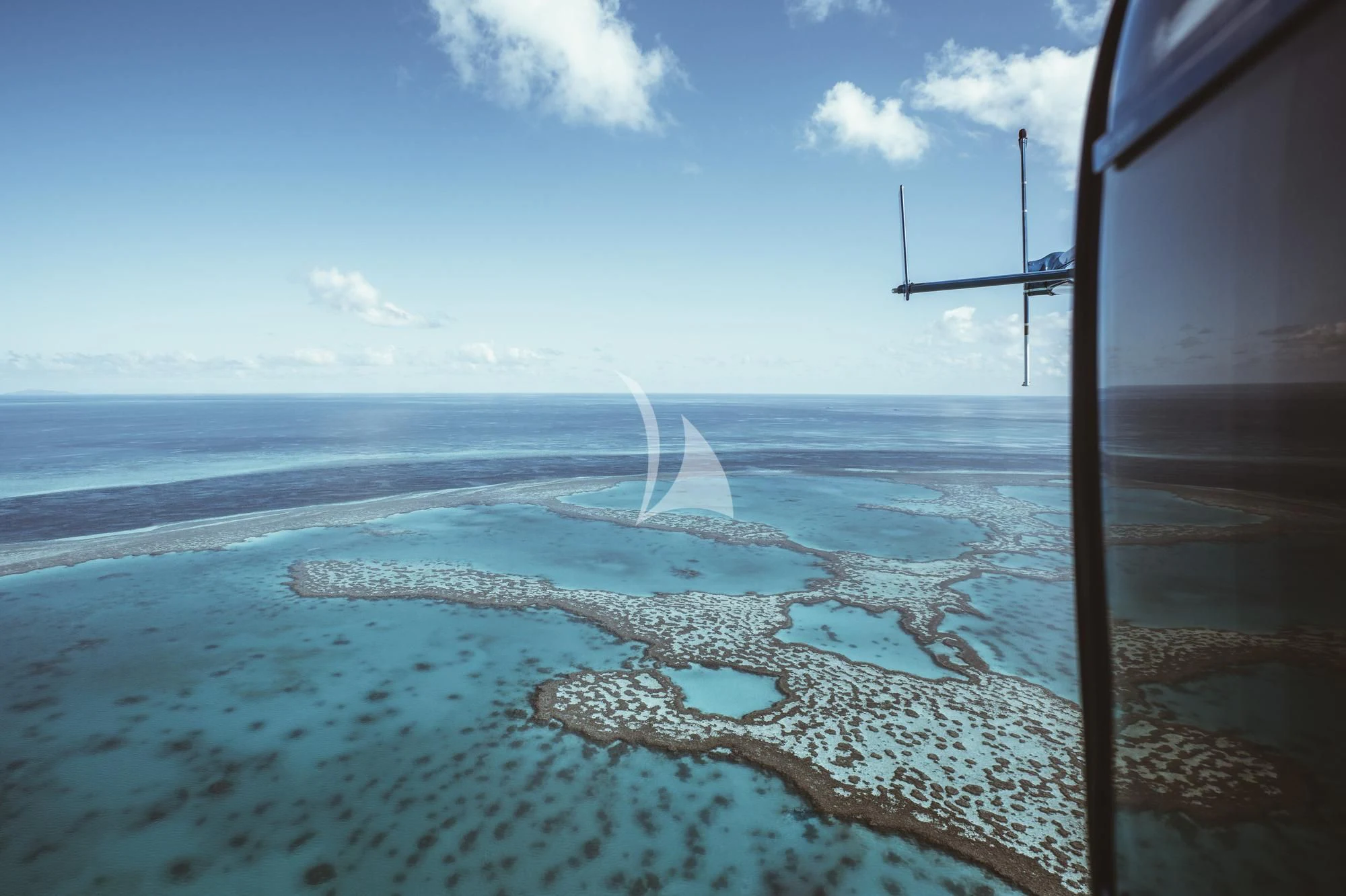 a plane wing over a beach aboard ONEWORLD Yacht for Sale