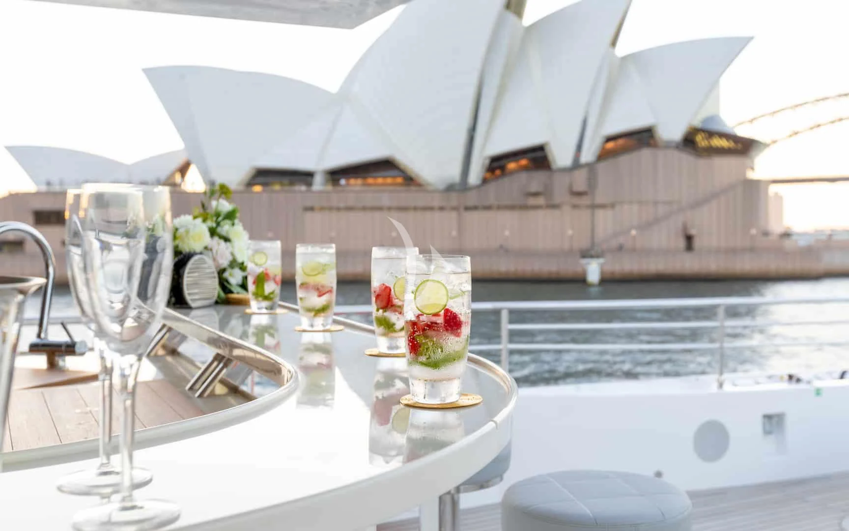 a table with glasses and flowers on it aboard ONEWORLD Yacht for Sale