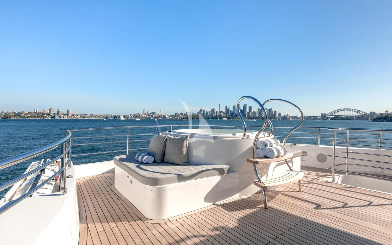 a lounge chair on a deck overlooking a body of water aboard ONEWORLD Yacht for Sale
