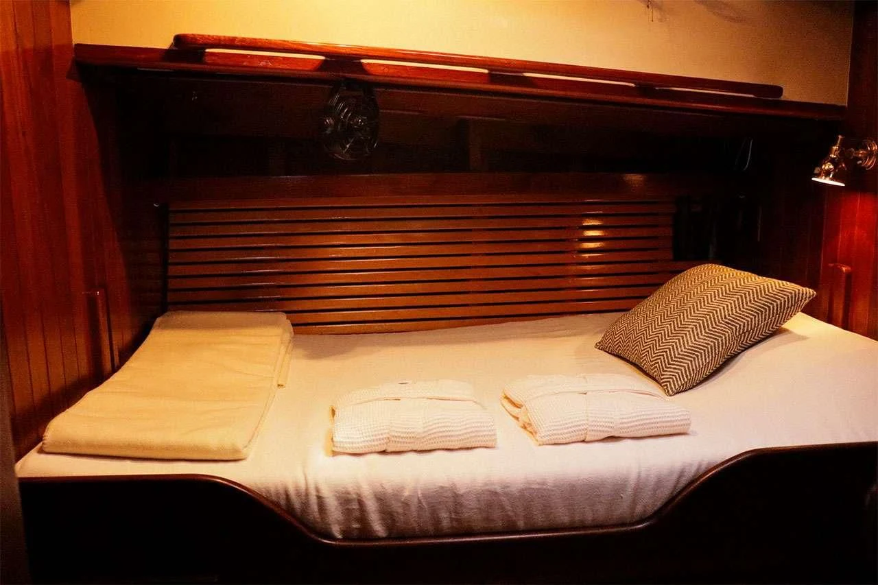 a bed with white sheets aboard TREE OF LIFE Yacht for Sale
