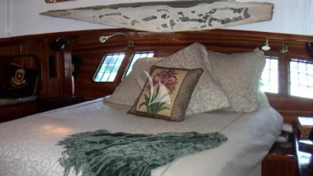 a bed with a white comforter and pillows aboard TREE OF LIFE Yacht for Sale
