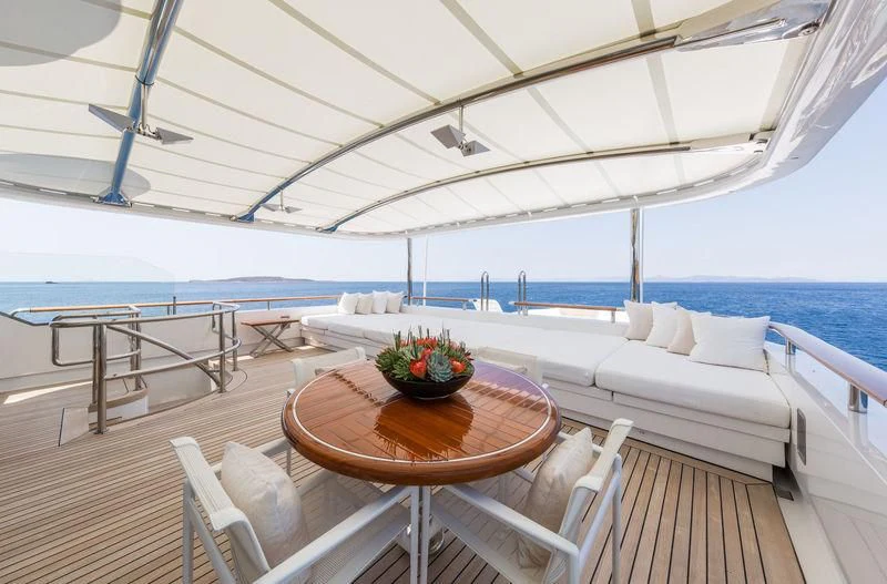 a table and chairs on a deck aboard ZEUS Yacht for Sale