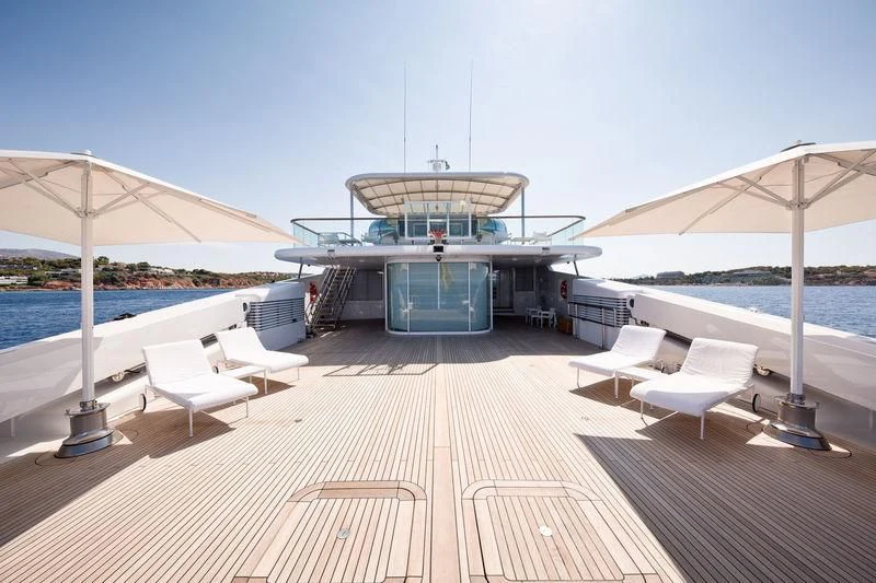 a deck with chairs and tables on it aboard ZEUS Yacht for Sale