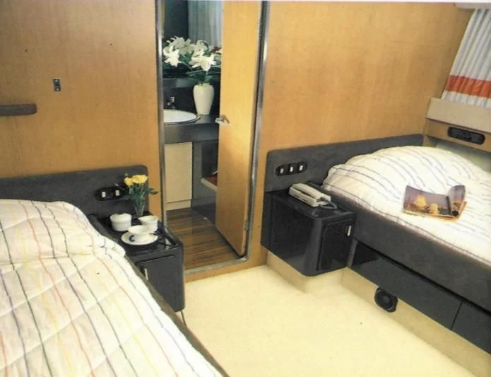 a bedroom with a bed and a desk aboard SOMETHING WILD Yacht for Sale