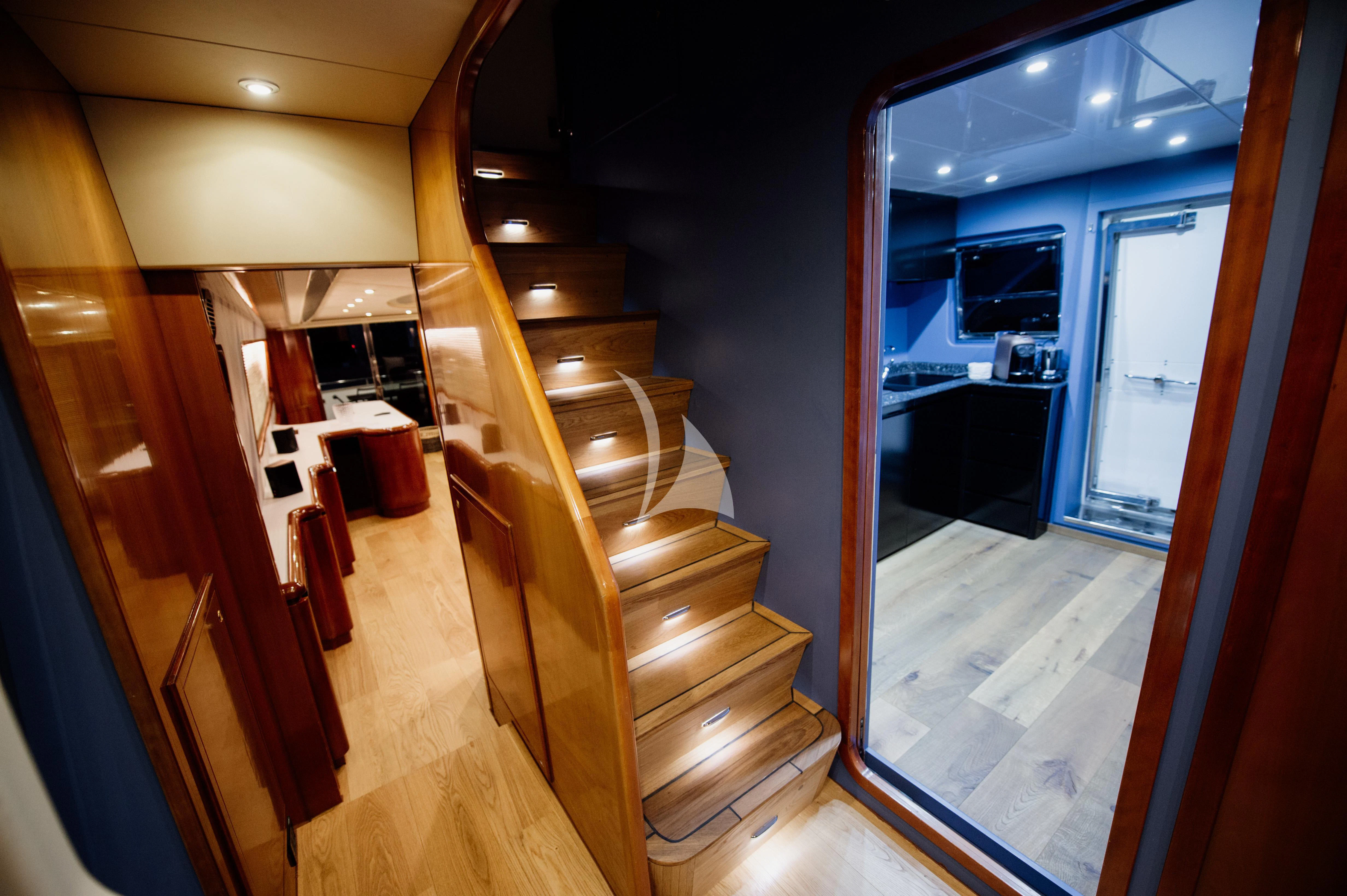 a hallway with a wood floor and a staircase aboard BEYOND Yacht for Charter