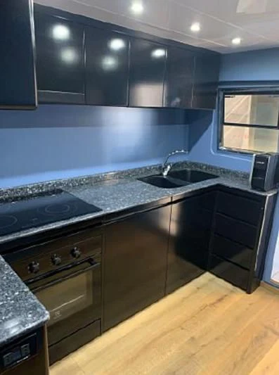 a kitchen with black cabinets aboard BEYOND Yacht for Charter