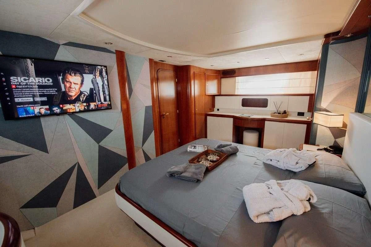 a bed with a television on the wall aboard BEYOND Yacht for Charter