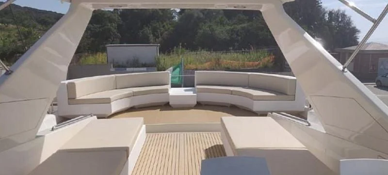 a room with a large window and a deck with a view of trees and grass aboard BEYOND Yacht for Charter