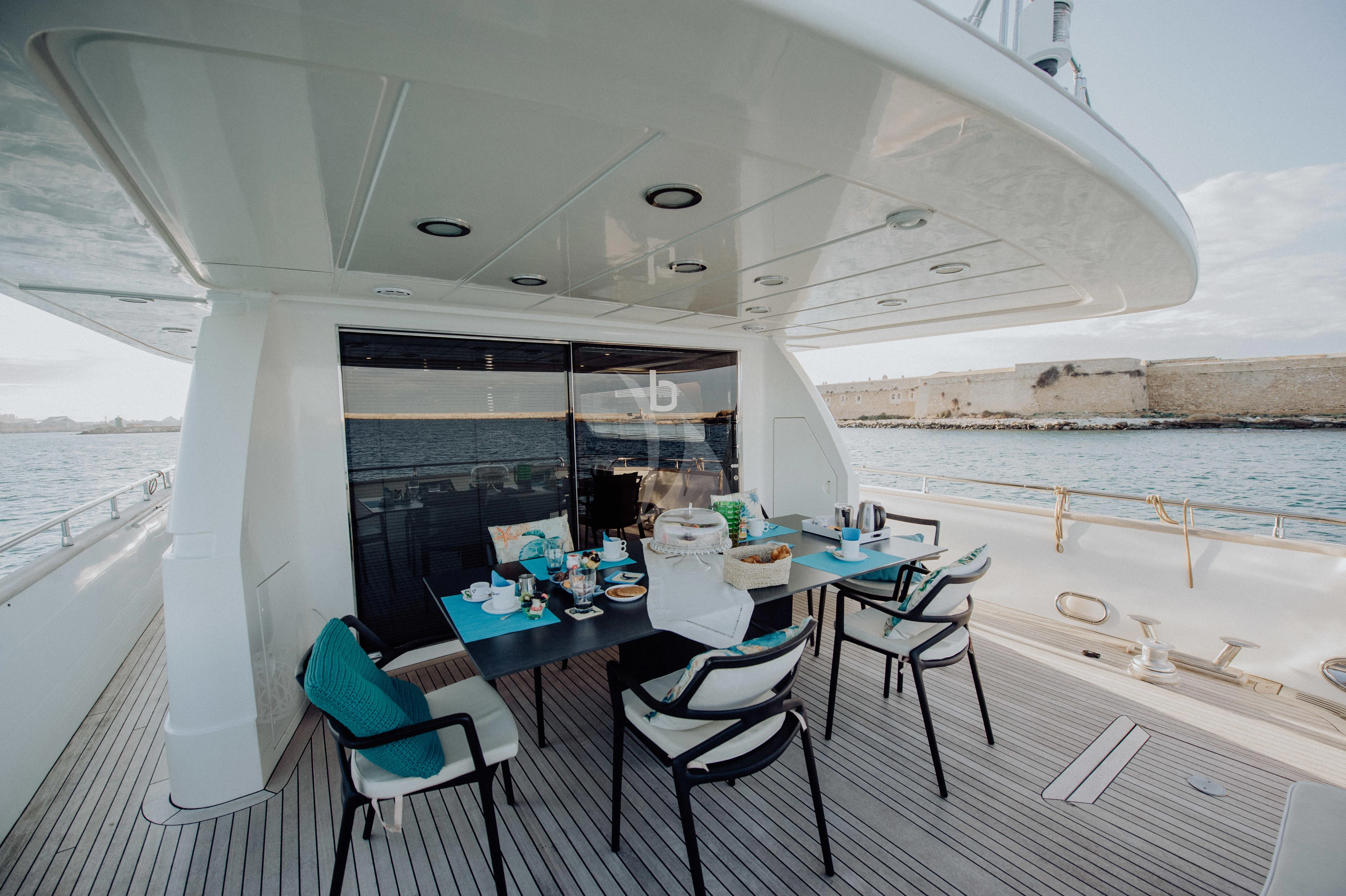 a table and chairs on a deck aboard BEYOND Yacht for Charter