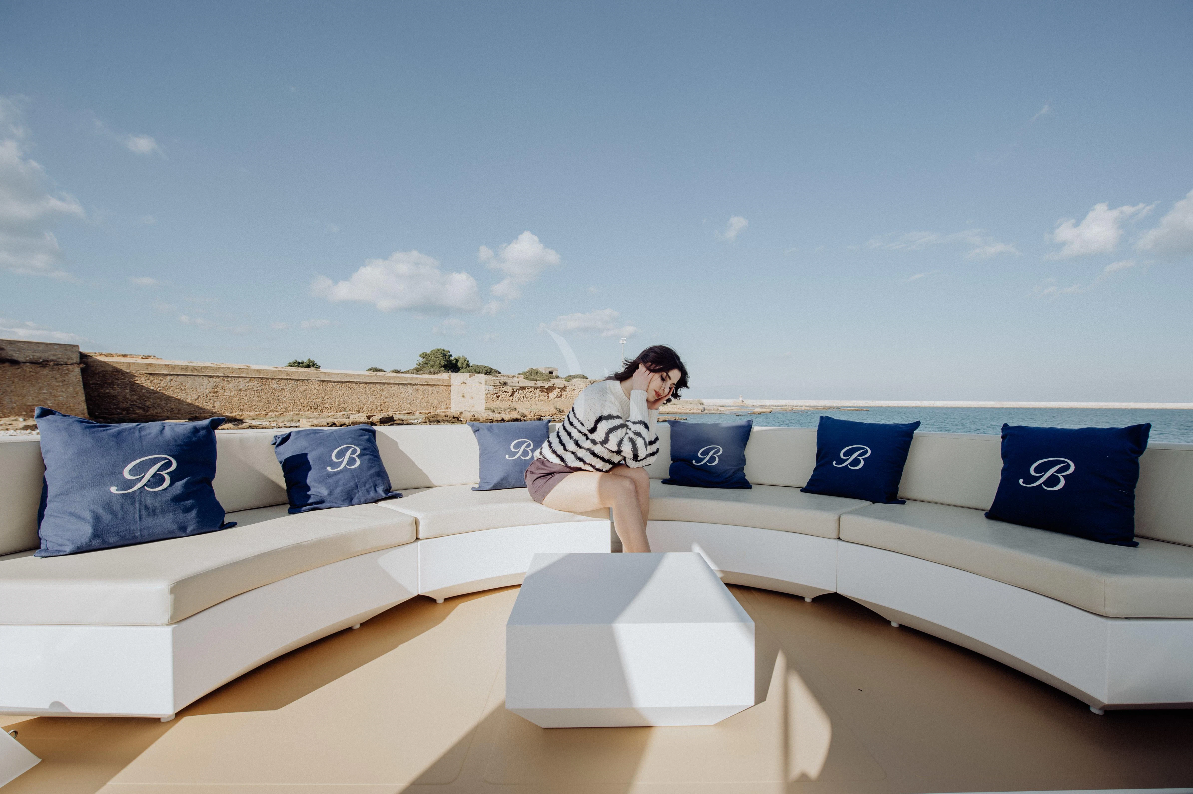 a person sitting on a couch aboard BEYOND Yacht for Charter